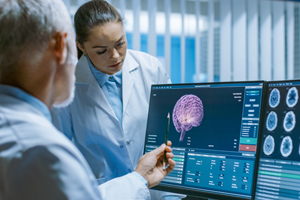 doctors looking at brain imaging on a computer monitor